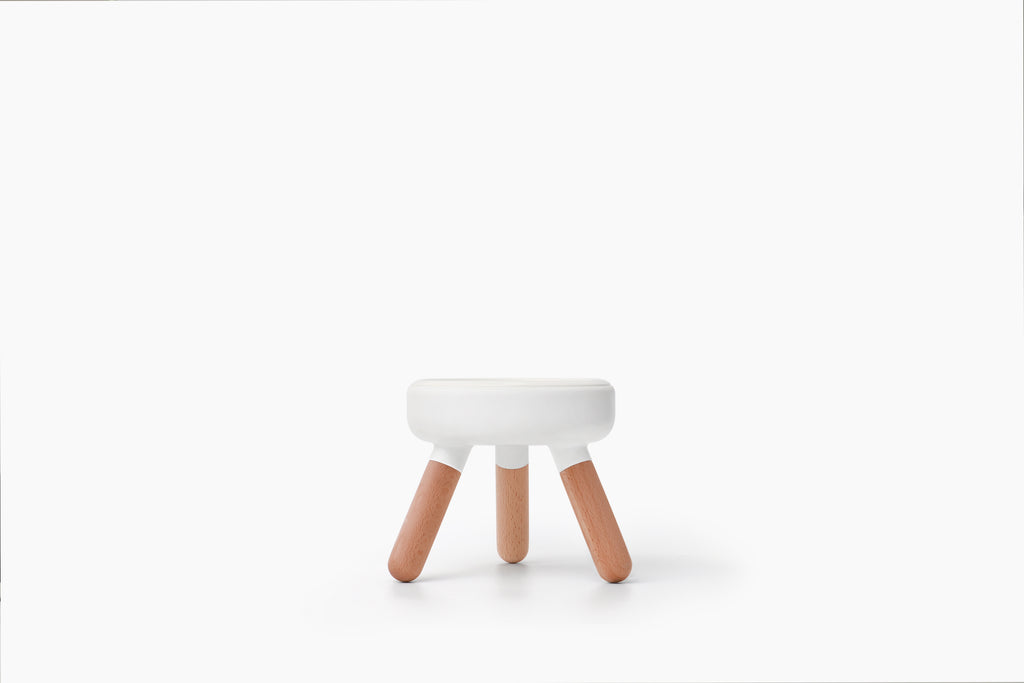 A small modern stool with a white circular seat and three light natural wood legs, centered on a clean white background.