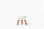 A small modern stool with a white circular seat and three light natural wood legs, centered on a clean white background.