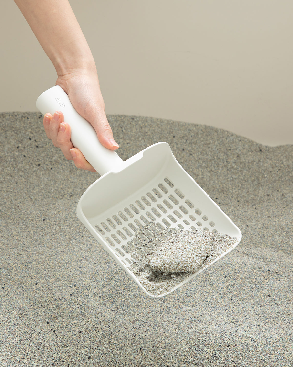 Sifting cat litter with white Poo Poo Cat Litter Scoop